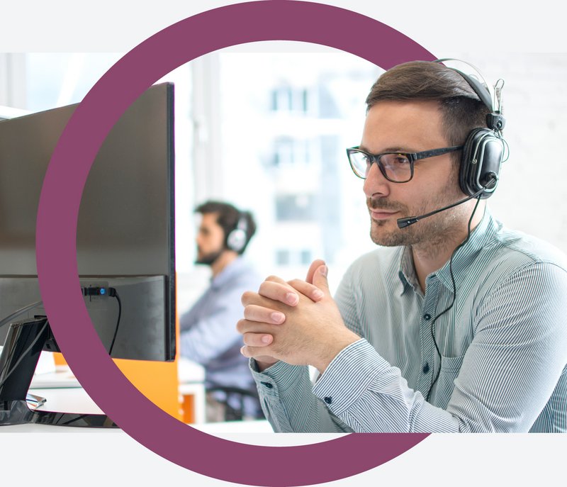 Servicedesk360 Titelbild Ein Servicedeskmitarbeiter mit Headset vor dem Computer