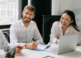Beitragsbild M365 Hacks Lachende Mitarbeitende bei der Arbeit im Büro