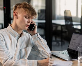 Beitragsbild: Telefonieren mit Teams Mitarbeiter telefoniert mit Mobile am Arbeitsplatz